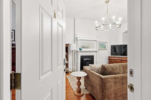 Ein Wohnzimmer mit Kamin, Fernseher und einer Couch.