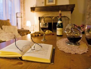 An open book on a table with glasses on top, a bottle of wine, a glass of wine, and a teapot. - Beny Duplex, (Grächen). Beny Duplex by Interhome (Grächen)