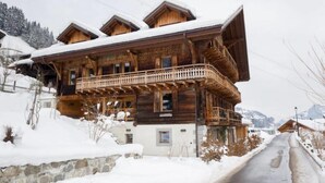 A wooden chalet with a balcony, surrounded by snow-covered ground and mountains. - Chalet François, (Champery). by Interhome (Champery)