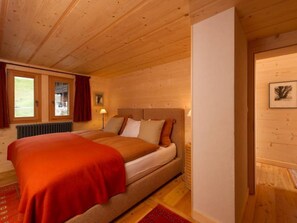 Une chambre dans une cabane en bois, avec un lit, une fenêtre et un radiateur.