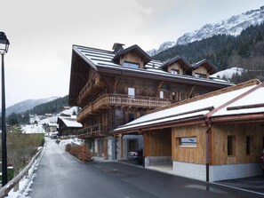 A wooden chalet with a balcony, a covered entrance, and a view of snow-covered mountains. - Chalet François, (Champery). by Interhome (Champery)