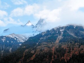 A mountain landscape with snow-covered peaks and a forested valley. - Chalet François, (Champery). by Interhome (Champery)