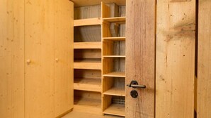 A wooden closet with multiple shelves and a door with a lock. - Chalet François, (Champery). by Interhome (Champery)