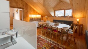A cozy attic room with a dining table, chairs, a radiator, and a window. - Chalet François, (Champery). by Interhome (Champery)