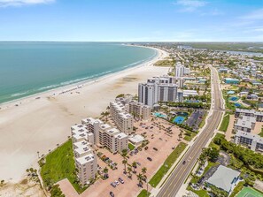 Eine Küstenstadtlandschaft mit Strand, Hochhäusern und einer Straße.
