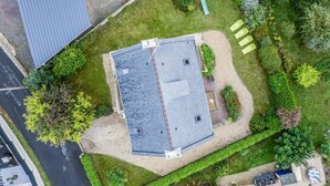 Een gebouw met een plat dak, omgeven door een verzorgd gazon en verschillende bomen.
