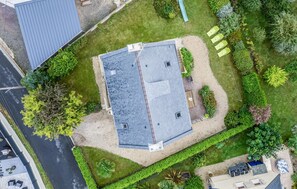 A building with a flat roof, surrounded by a well-maintained lawn and various trees. - Awesome home in Lézardrieux with WiFi (Lézardrieux)