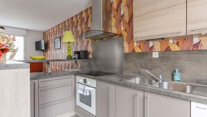 Een moderne keuken met een ingebouwde oven, een RVS spoelbak en een decoratieve spatwand.