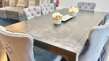 Un comedor con una mesa rectangular, sillas tapizadas en gris y un centro de mesa decorativo.