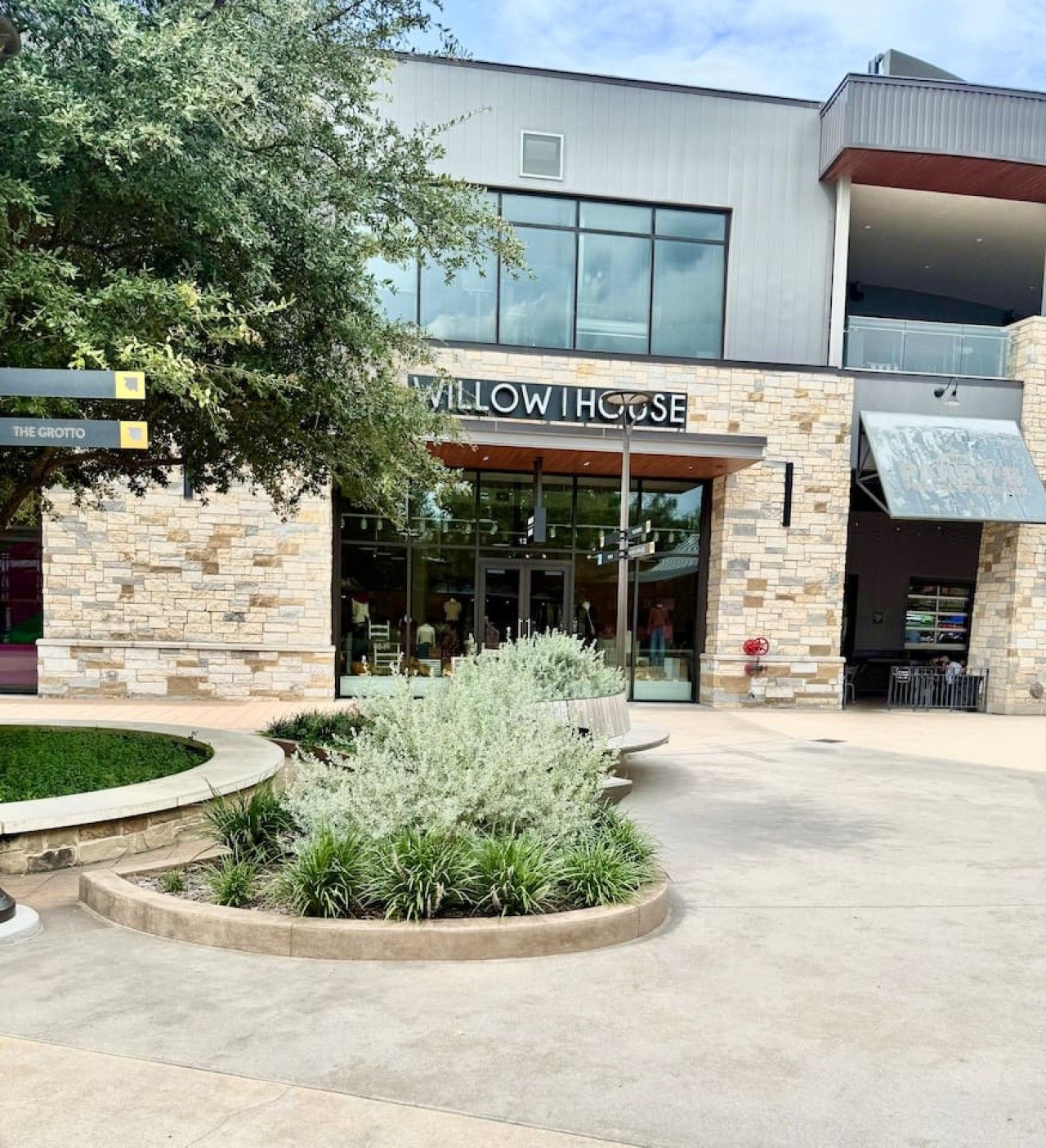 A building with a sign reading 'MALLOW HOUSE' and a landscaped area with plants in front.