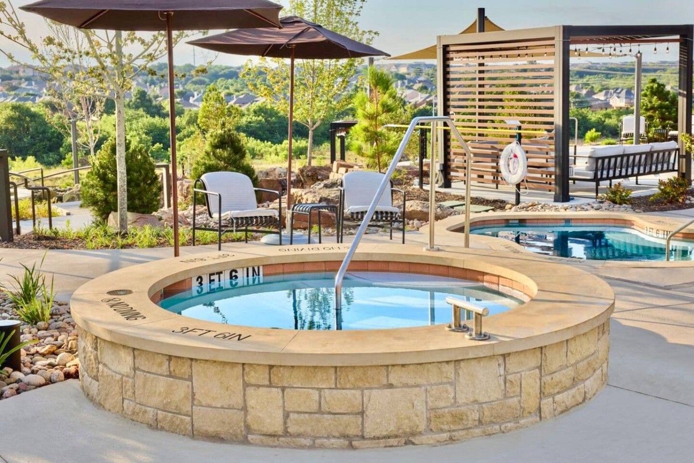 A hot tub with '3ETGIN' text, surrounded by outdoor seating and a pool.