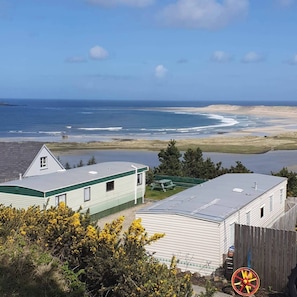 A coastal view with a house and a trailer, a sandy beach, and the ocean. - Donegal Mobile Home-Coast-Family Friendly-Sleeps 5 (Letterkenny)