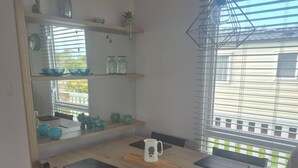 A dining area with a wooden table, four chairs, and a window with blinds. - 2 x Cabin Retreat in Coldingham (Coldingham)