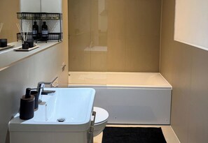 Ein modernes Badezimmer mit einem weißen Waschbecken, einer Badewanne und einer Duschkabine.