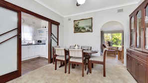 A dining area with a round table, chairs, and a painting on the wall. - Morpeth Cottage | In the hear of Morpeth (Morpeth)