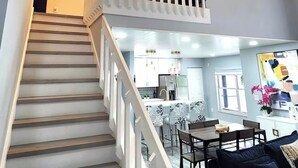Una escalera conduce a un balcón con una lámpara colgante.