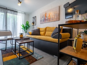 Ein modernes Wohnzimmer mit einer Couch, einem Couchtisch und einem Essbereich mit einem kleinen Tisch und Stühlen.