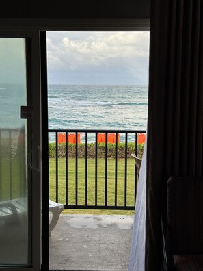 A view from a room with a sliding glass door to a balcony overlooking the ocean. - Wake up to the sunrise from your balcony - Oceanfront 1 BR condo Pono Kai Kapa'a (Kapaʻa)