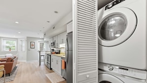 A modern kitchen with a built-in washer and dryer, a dining area with a sofa, and a view of the outdoors. - Dupont Circle 1BR with laundry/AC/kitchen (Washington)