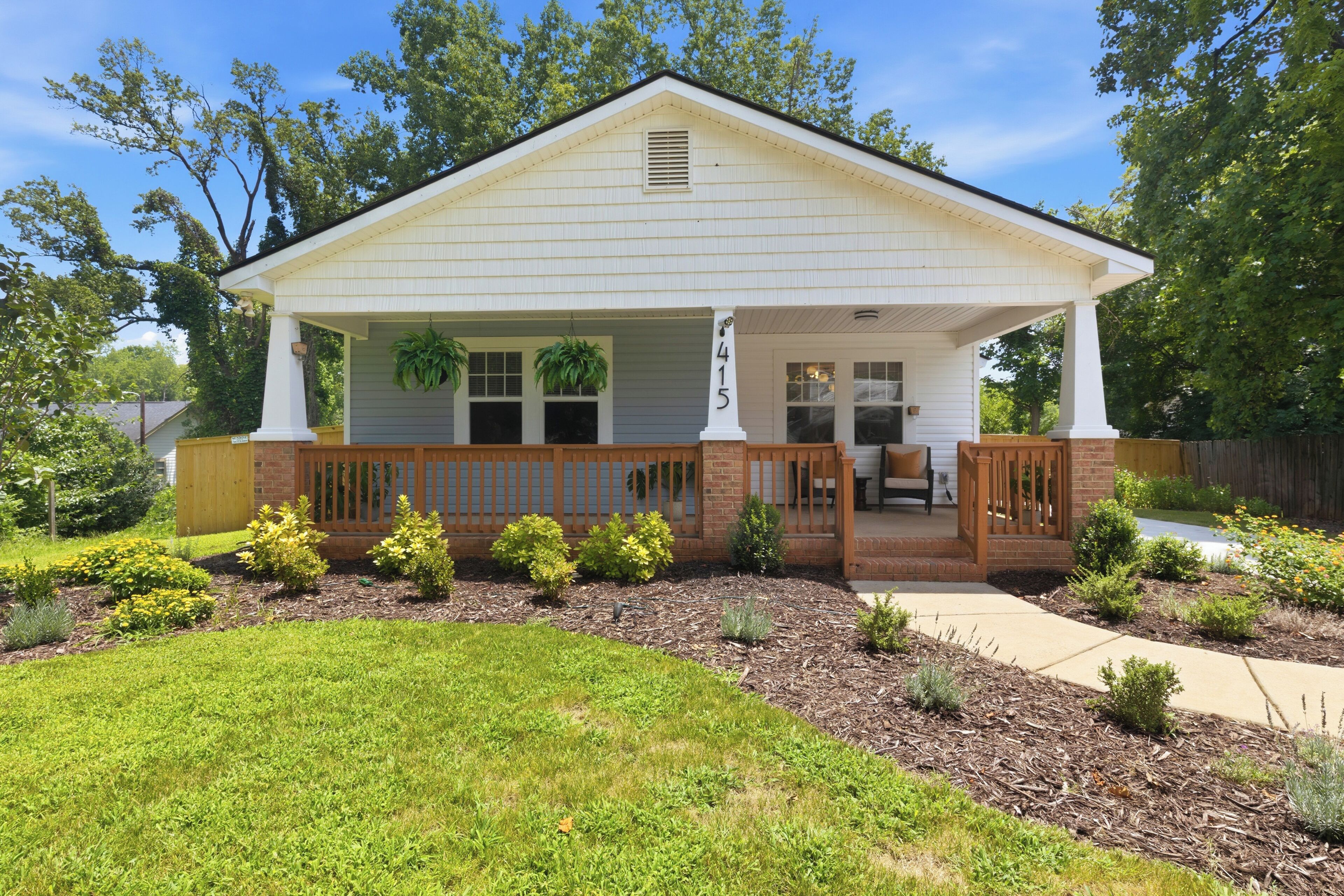 A single-story house with a front porch, a mailbox, and a well-maintained lawn.