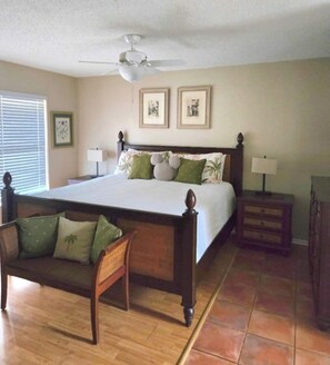 A bedroom with a large bed, a nightstand, a chair, a ceiling fan, and two framed pictures on the wall. - Casa Bearclaw Family Getaway Disney4 Miles 2 bedroom/2bathroom Pet Friendly (Kissimmee)