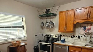 A kitchen with a stove, oven, and dishwasher. There are wooden cabinets and a window with blinds. - Casa Bearclaw Family Getaway Disney4 Miles 2 bedroom/2bathroom Pet Friendly (Kissimmee)
