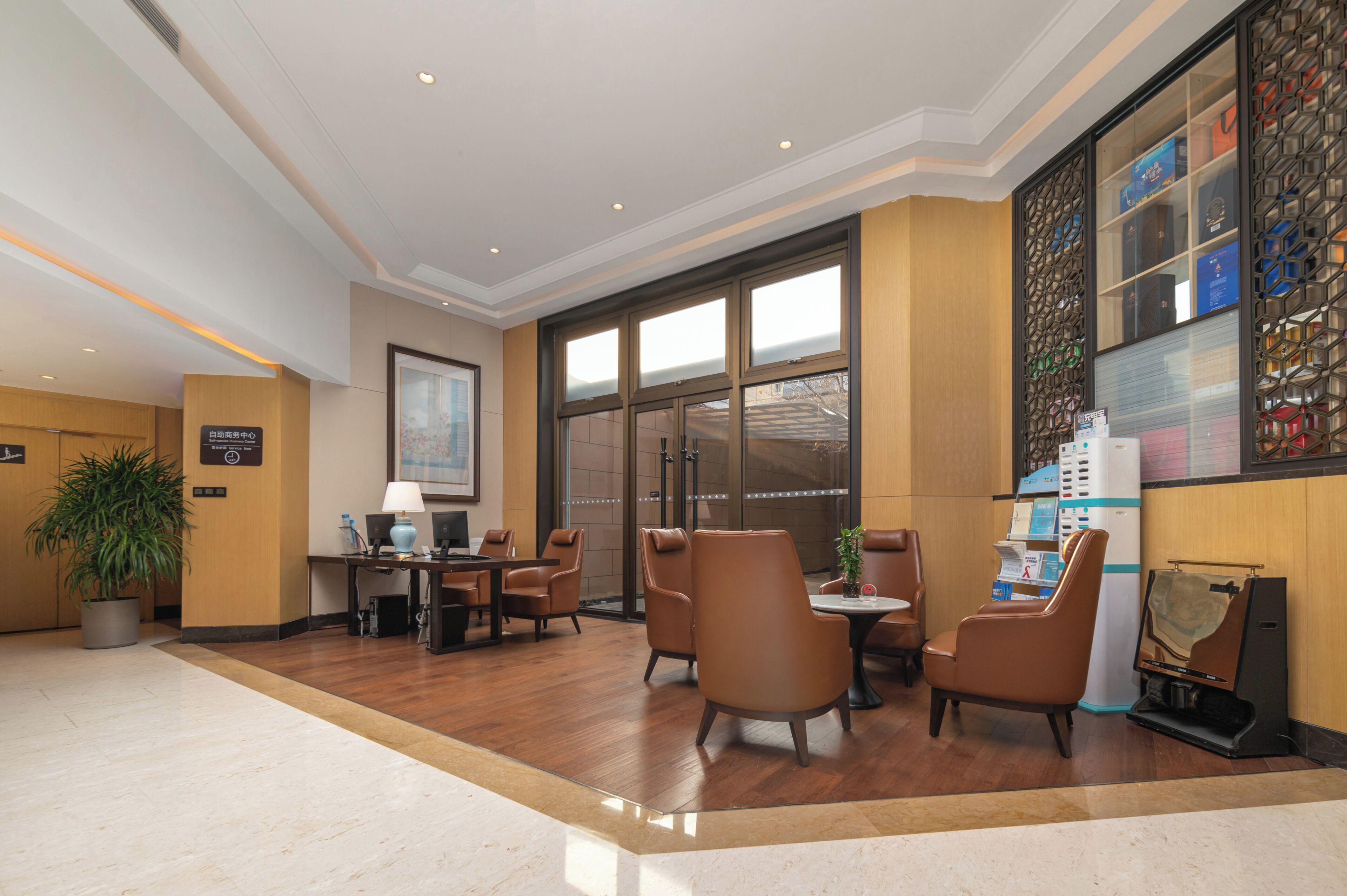 A lobby with a reception desk, seating area, and a large window.