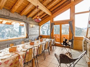 A dining area with wooden beams, large windows, and a view of snow-covered mountains. - Balcon du Paradis by Interhome (Peisey-Nancroix)