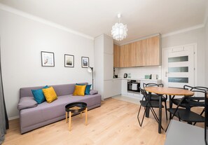 A modern apartment with a living area, kitchenette, and dining space. - Wola Ratusz Comfort Apartment (Warszawa)