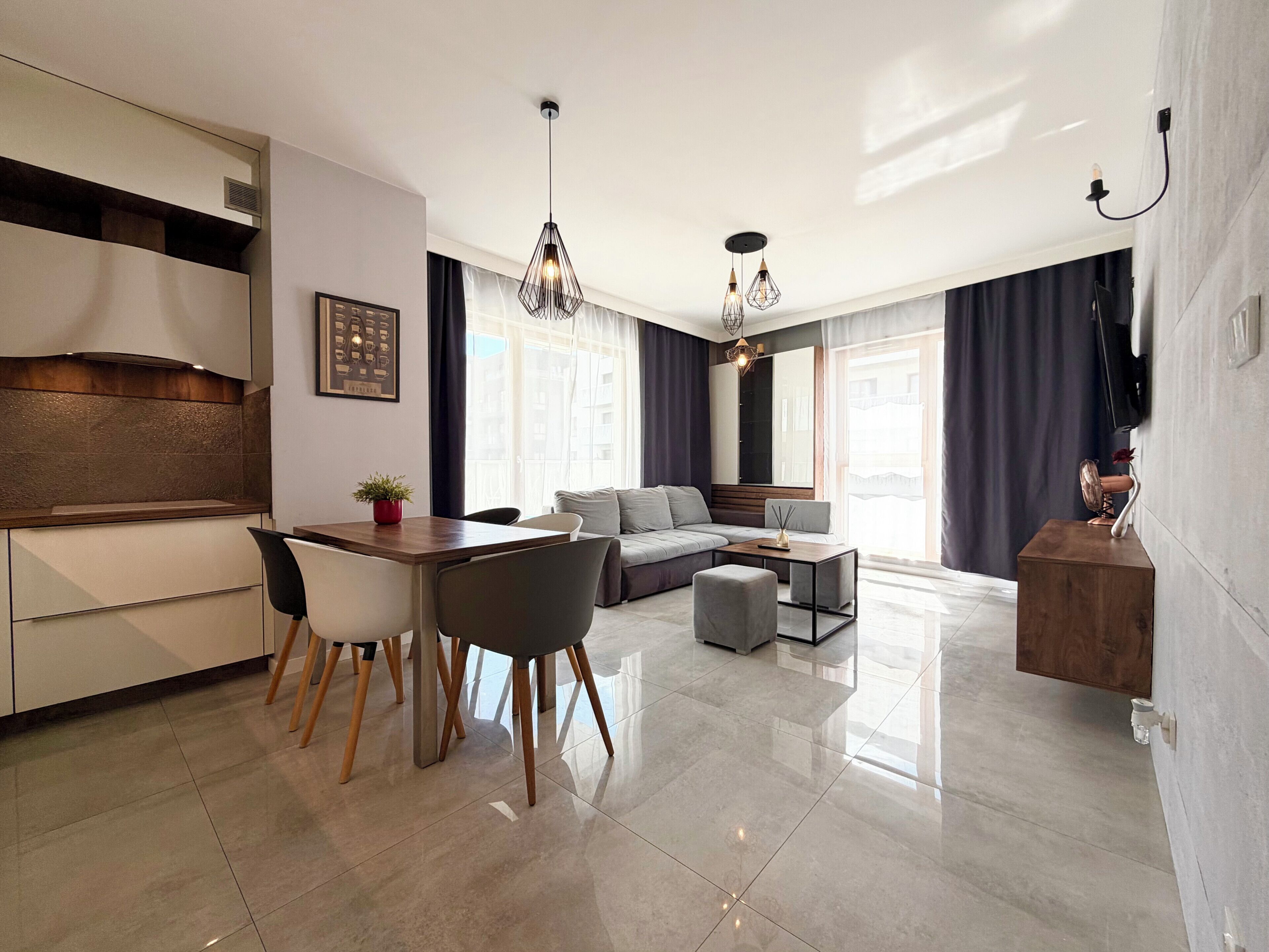 A modern living space with a kitchen, dining area, and seating area.