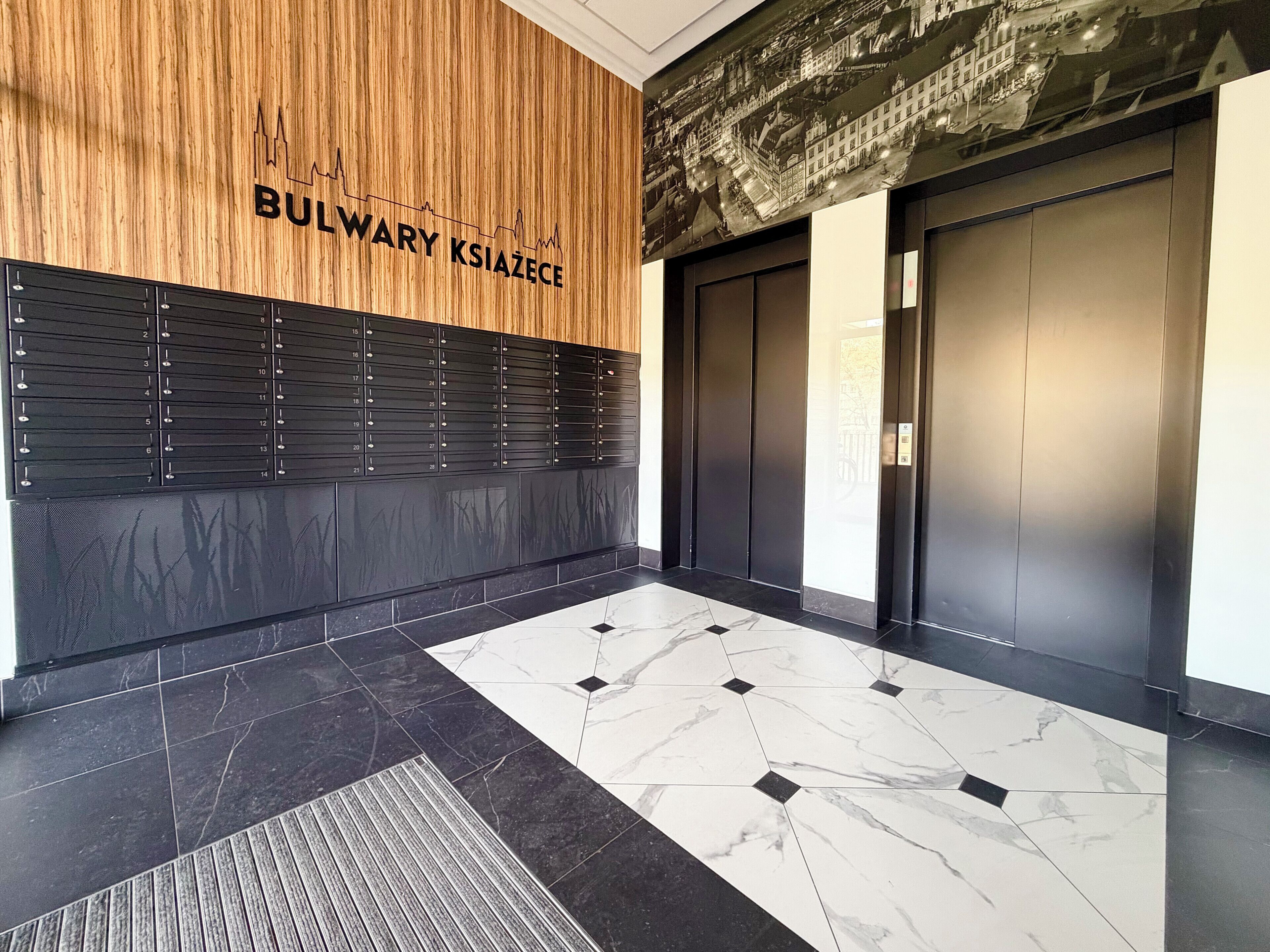 A modern elevator area with a wooden panel wall, a black panel with a number list, and a marble-tiled floor.