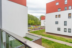 A modern building with a flat roof, a children's playground, and a clear sky. - Koszalińska Harmony Apartment (Kołobrzeg)