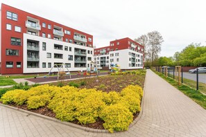 Un moderno edificio residenziale con diversi balconi e un giardino curato.
