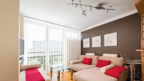 Ein modernes Wohnzimmer mit einer Sofagarnitur, einem Glastisch und einer Deckenleuchte.