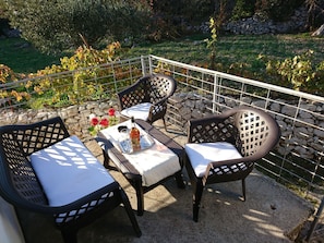 An outdoor patio with a table set for two, surrounded by chairs with lattice backs. - Vollständig eingerichtetes Haus mit privater Sonnenterrasse by Interhome (Lecevica)