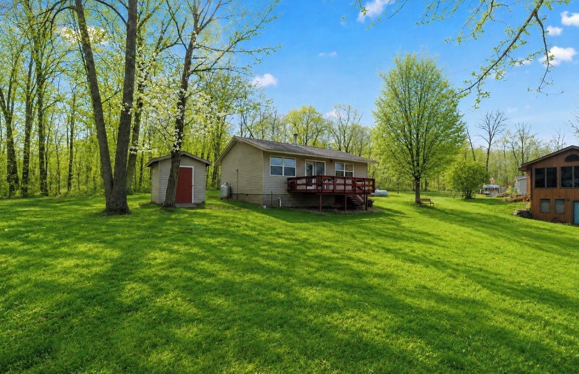 A residential property with a main house, a small shed, and a deck.