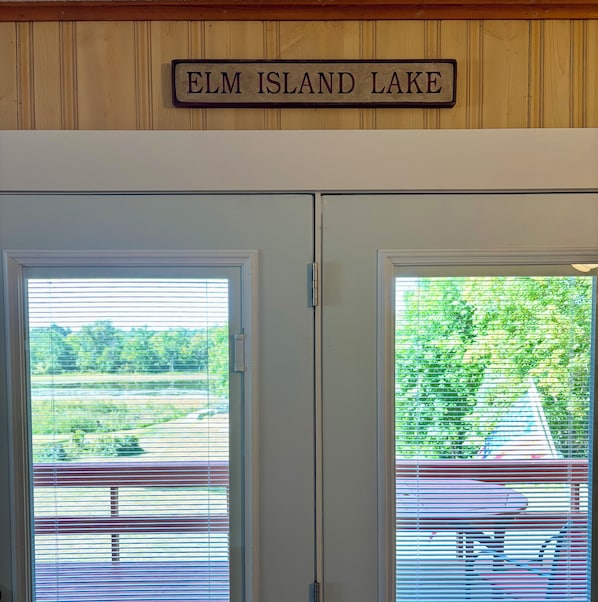 A door with a sign above it reading 'ELM ISLAND LAKE'.