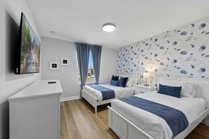 A hotel room with two beds, a TV, a desk, and a window with curtains. - Brand New | 4Bd Private Pool, Resort Near Disney  4993 (Kissimmee)