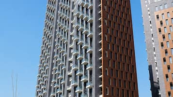 Um edifício moderno de grande altura com fachada única, apresentando uma combinação de padrões geométricos e varandas.