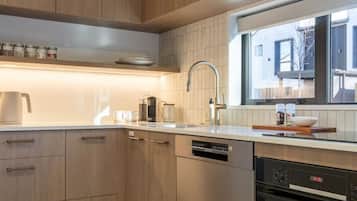 A modern kitchen with wooden cabinets, a stainless steel sink, and a built-in oven.