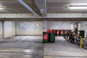 Eine Tiefgarage mit Betonwänden, einer Decke mit Rohren und mehreren abgestellten Fahrrädern.