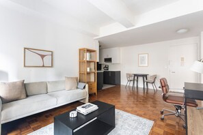 Moderni olohuone, jossa on sohva, sohvapöytä ja kirjahylly.