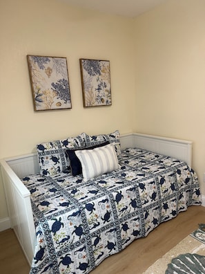 Ein Schlafzimmer mit einem Bett, einem weißen Heizkörper und zwei Wandbildern.