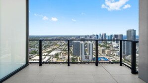 Ein Balkon mit Blick auf die Stadt, einem Metallgeländer und einem gefliesten Boden.