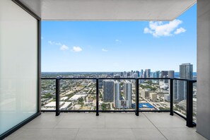 Ein Balkon mit Blick auf die Stadt, einem Metallgeländer und einem gefliesten Boden.