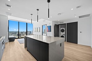 A modern kitchen with a large island, built-in appliances, and a city view. - Exclusive 2BR Luxury Residence at The E11even (Miami)