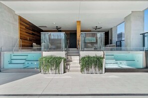 Ein moderner Poolbereich im Innenbereich mit Glasgeländern, einer Treppe und Topfpflanzen.