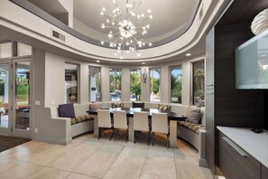 A modern dining area with a curved ceiling and a central chandelier. - $5Mil Luxury Estate - Pickleball Pool Hot Tub (Scottsdale)