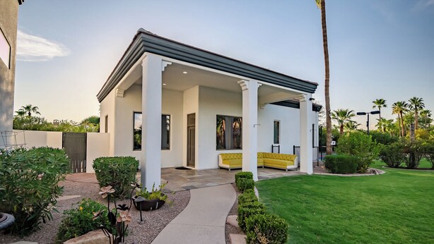 A modern house with a covered patio, a well-maintained lawn, and a variety of plants. - $5Mil Luxury Estate - Pickleball Pool Hot Tub (Scottsdale)