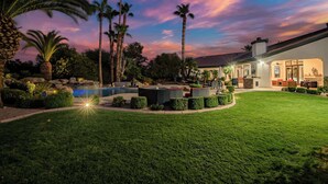 A well-maintained outdoor area with a swimming pool, seating, and a modern building with large windows. - $5Mil Luxury Estate - Pickleball Pool Hot Tub (Scottsdale)